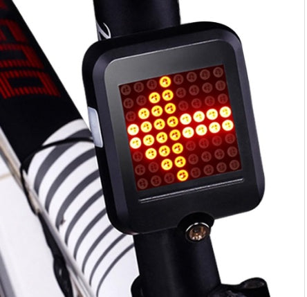 Bicycle tail light with red and yellow LED pattern on a bike frame.