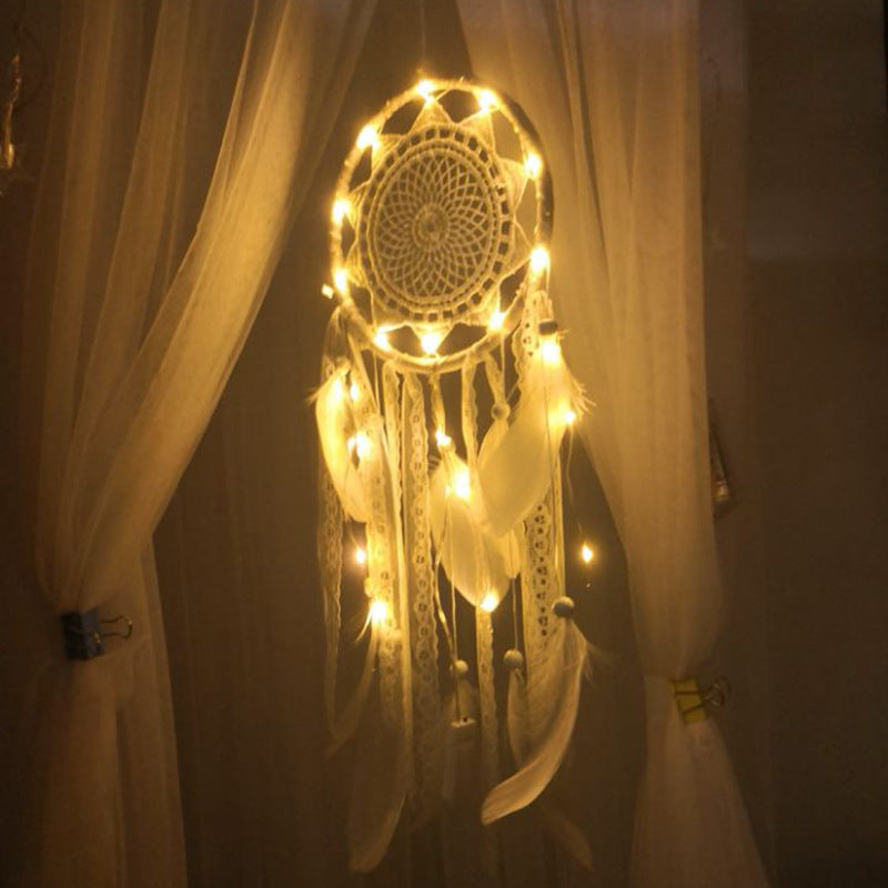 Decorative dreamcatcher with lights hanging against a dark background