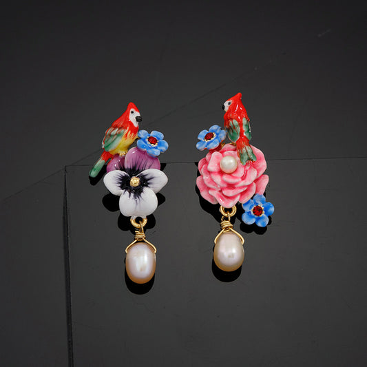 Colorful parrot and floral earrings on a black background