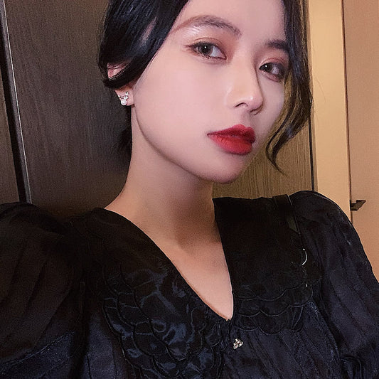 Woman wearing a black dress with a close-up of her face.