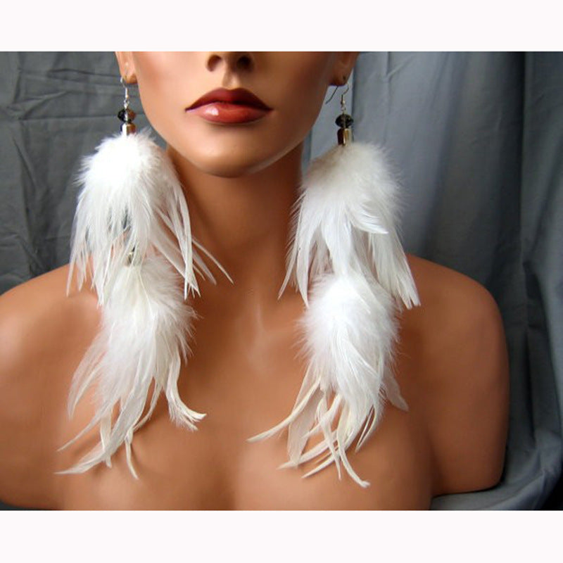 White feather earrings on a model against a neutral background