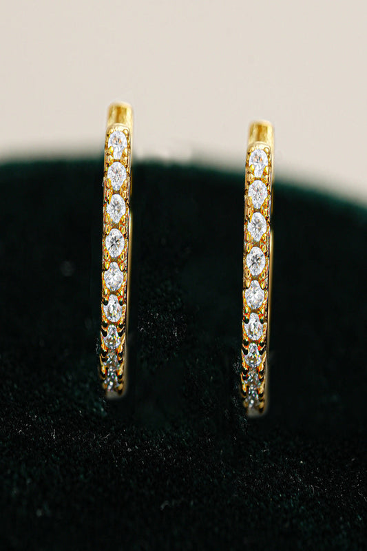 Gold hoop earrings with diamond accents on a black background