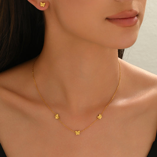 Gold necklace with butterfly pendants worn by a model