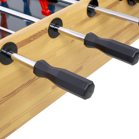 Close-up of a foosball table with wooden surface and metal rods.