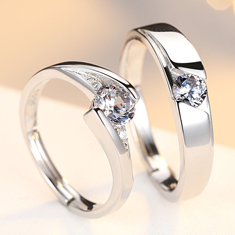 Two silver rings with clear gemstones on a light background