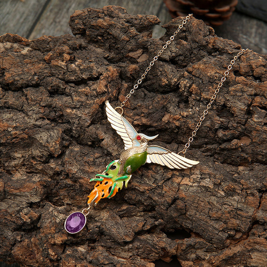 Bird-shaped necklace with a purple pendant on a wooden surface