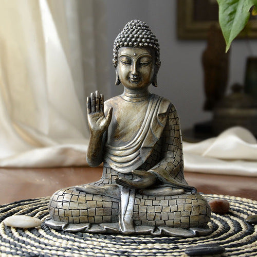 Bronze Buddha statue on a textured surface with a blurred background