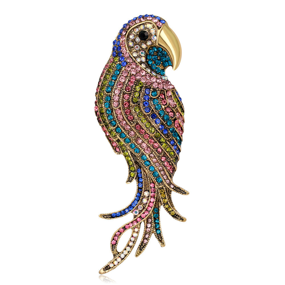 Colorful parrot-shaped brooch with gemstones on a white background
