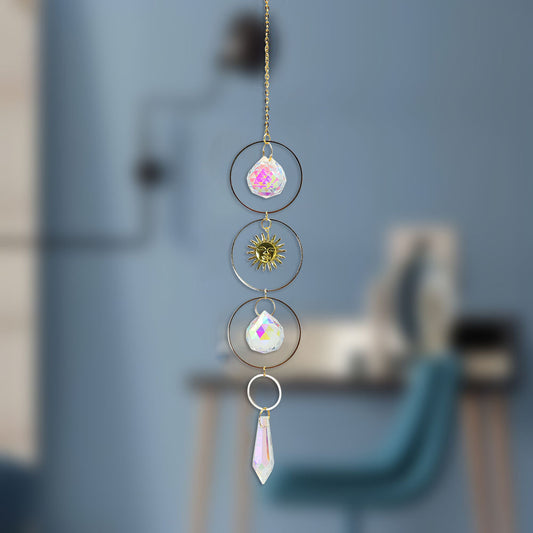 Decorative hanging crystal with colorful teardrop shapes against a blurred background