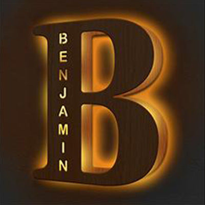 Wooden letter 'B' with 'Benjamin' engraved on a dark background