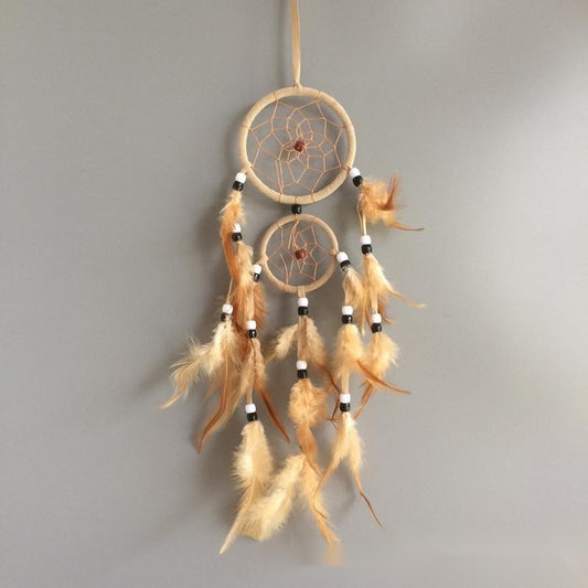 Dreamcatcher with feathers on a gray background