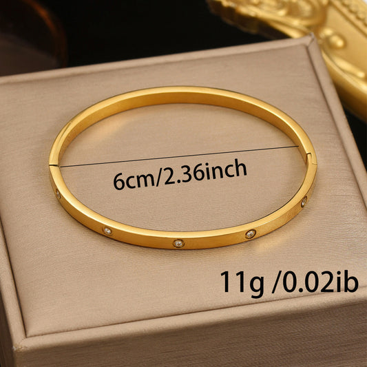Gold bracelet on a beige box with measurements displayed