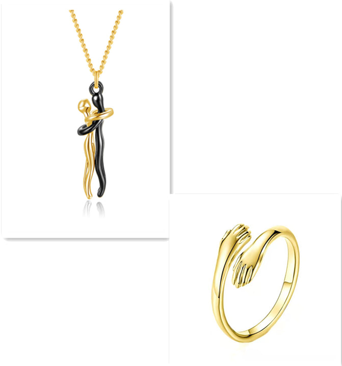 Gold and black pendant necklace and gold ring on a white background