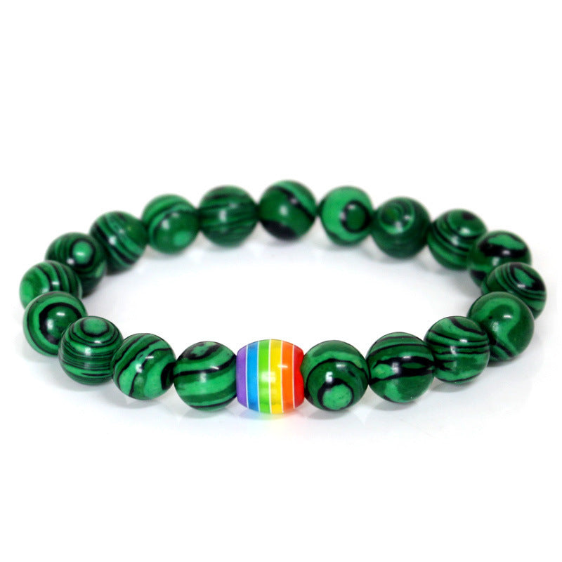 Green beaded bracelet with a rainbow center bead on a white background