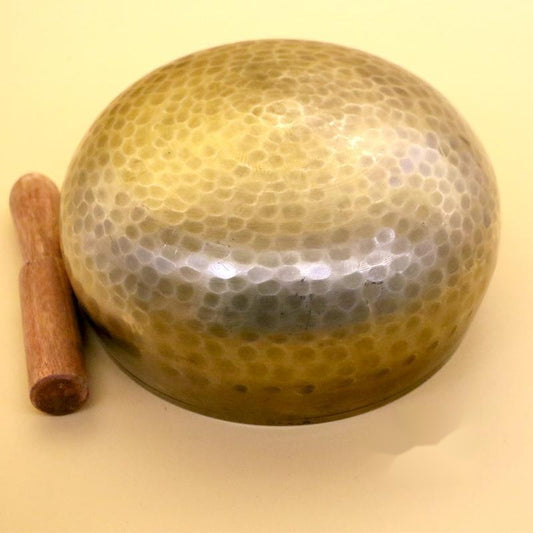 Handmade-Nepalese-singing-bowl-for-chakra Decorative stone with a cylindrical object on a beige background