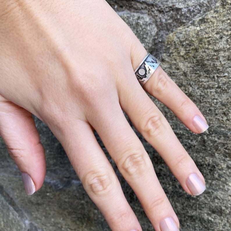 Hand with a ring on a textured stone background