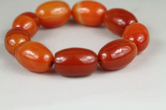 Beaded bracelet with orange beads on a white background