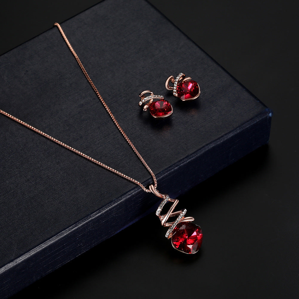 Jewelry set with red gemstones on a dark surface