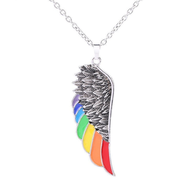 Necklace with a rainbow-colored wing pendant on a white background