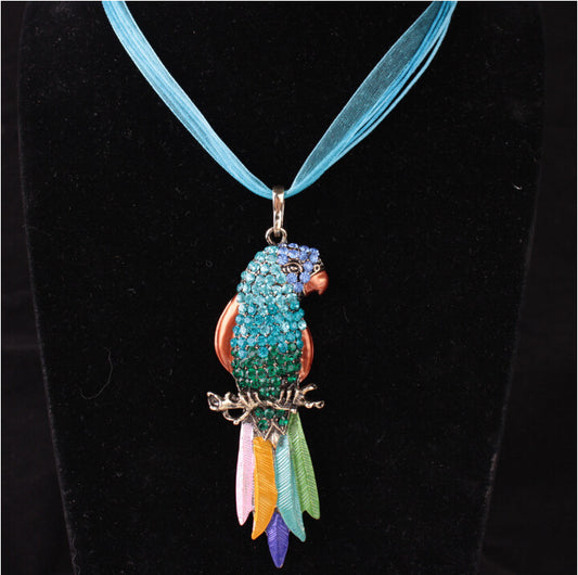 Colorful parrot-shaped pendant on a blue ribbon against a black background