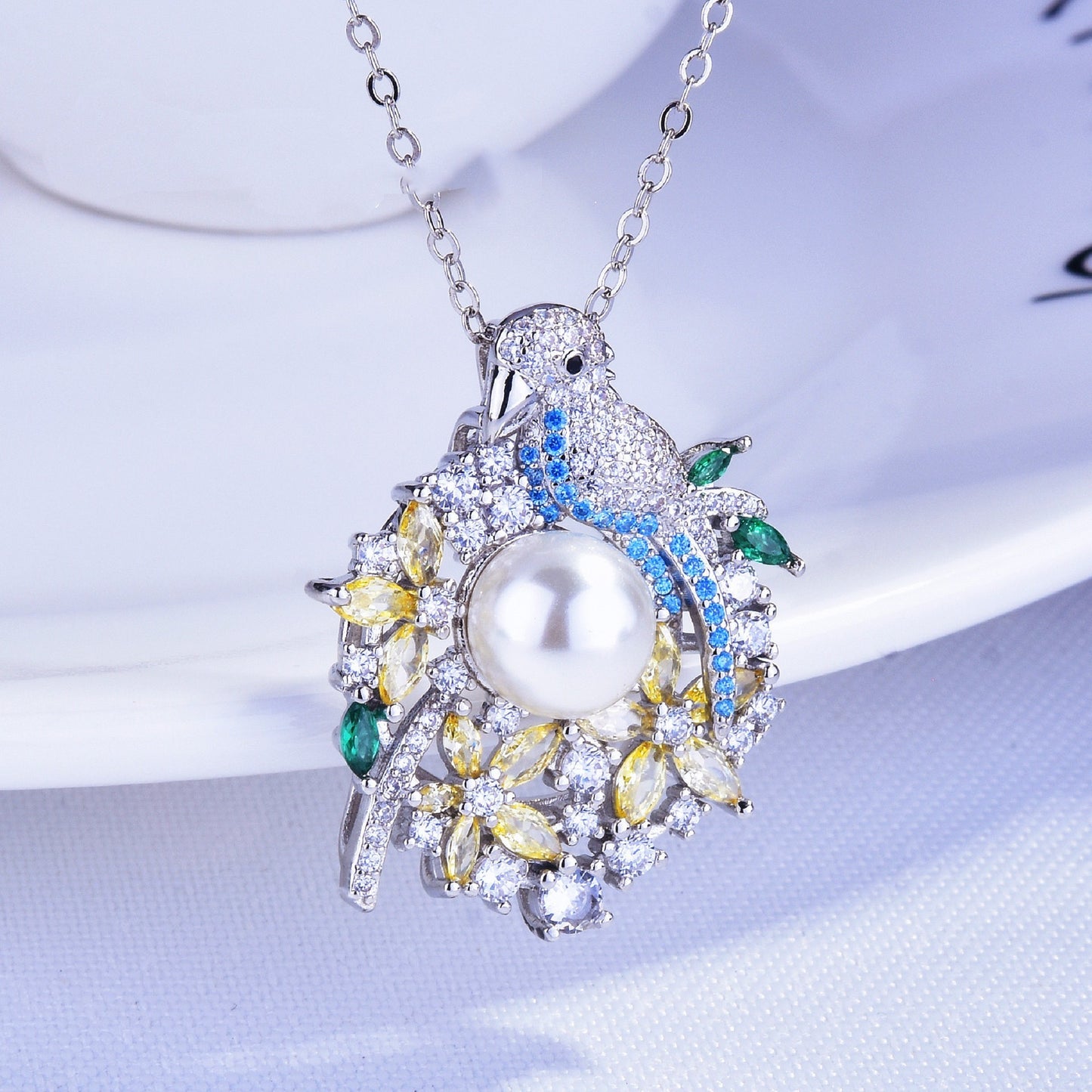 Elegant necklace with a pearl pendant and gemstones on a white background