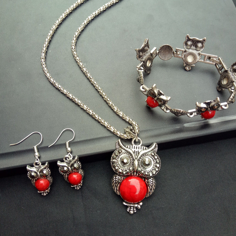 Red Vintage Turquoise Owl Jewelry Set Necklace Earrings Bracelet on a table