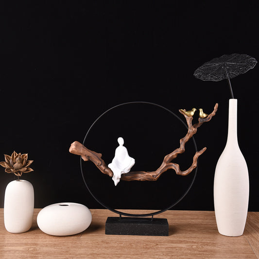 Decorative setup with a white figure on a branch, white vases, and a black background