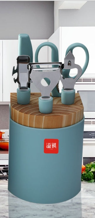 Set of kitchen utensils in a blue holder with a wooden top on a kitchen counter.