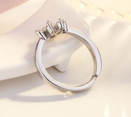 Silver ring with a diamond on a white surface