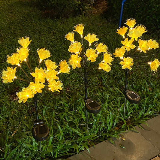 Solar-powered yellow flower lights on grass