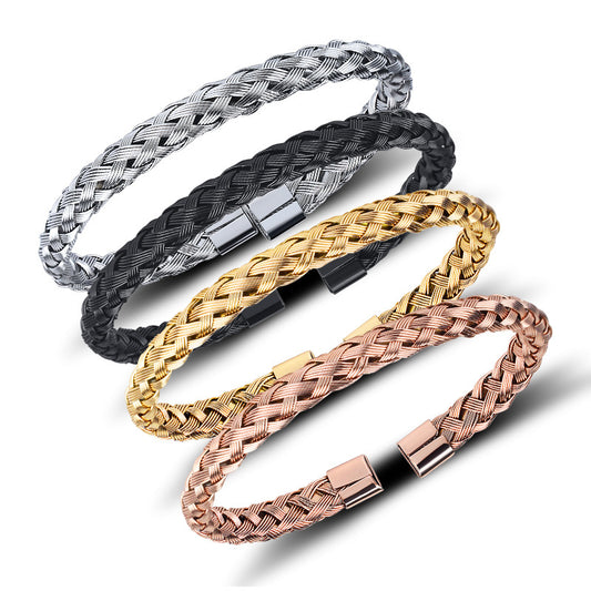 Four braided bracelets in silver, black, gold, and rose gold on a white background