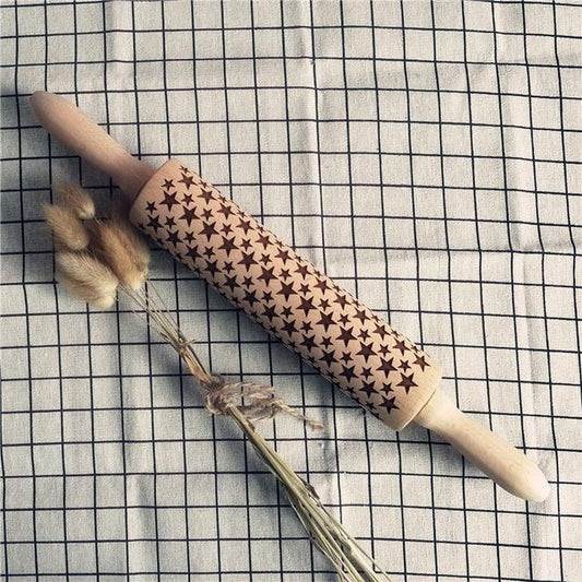 Wooden rolling pin with star pattern on a checkered fabric background