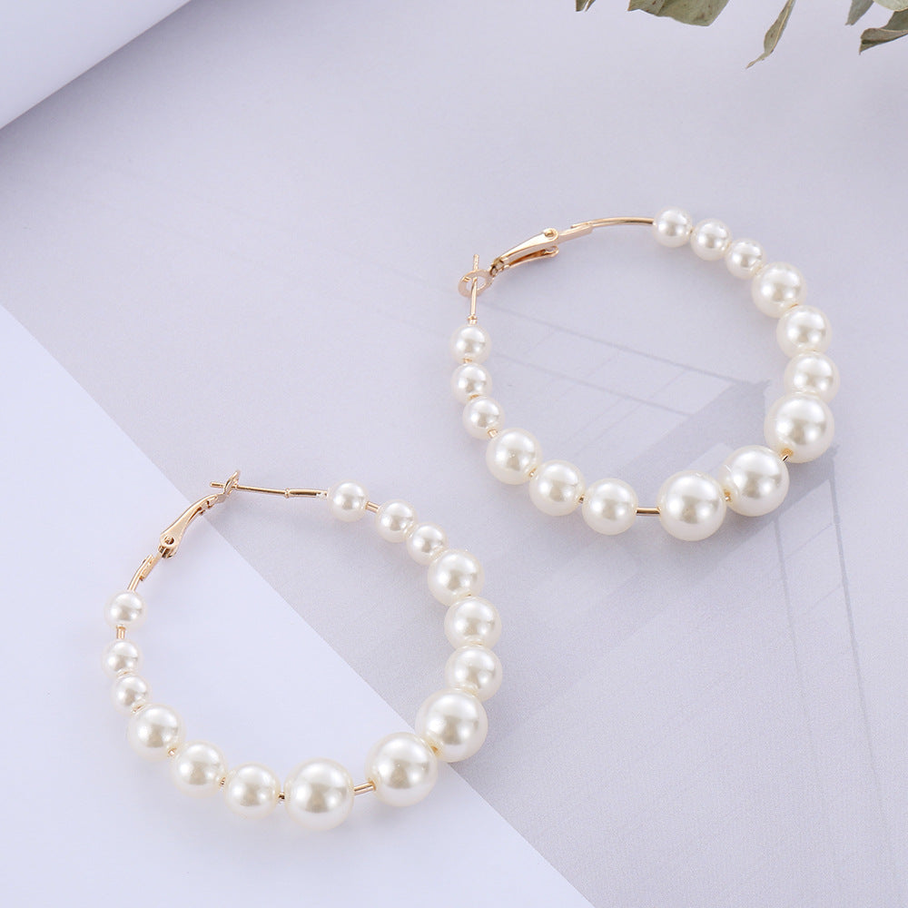 Pearl hoop earrings on a light gray background