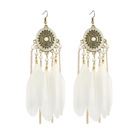 Pair of earrings with white feather-like pendants and gold chains on a white background
