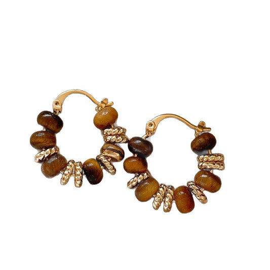 Pair of gold and brown beaded earrings on a white background from nested wisdom