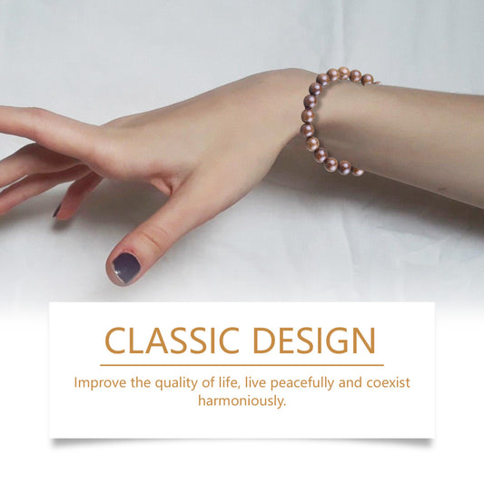 Hand wearing a pink beaded bracelet with a motivational quote on a white background