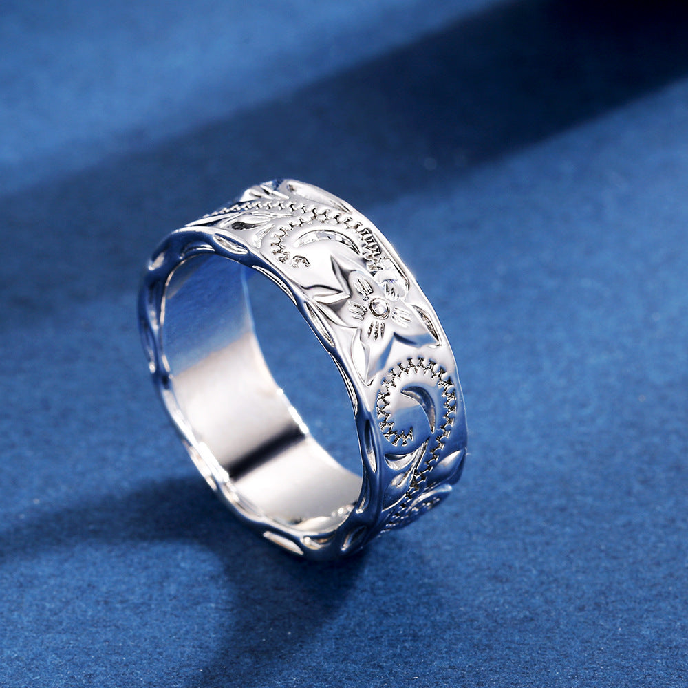 Silver ring with intricate designs on a blue background