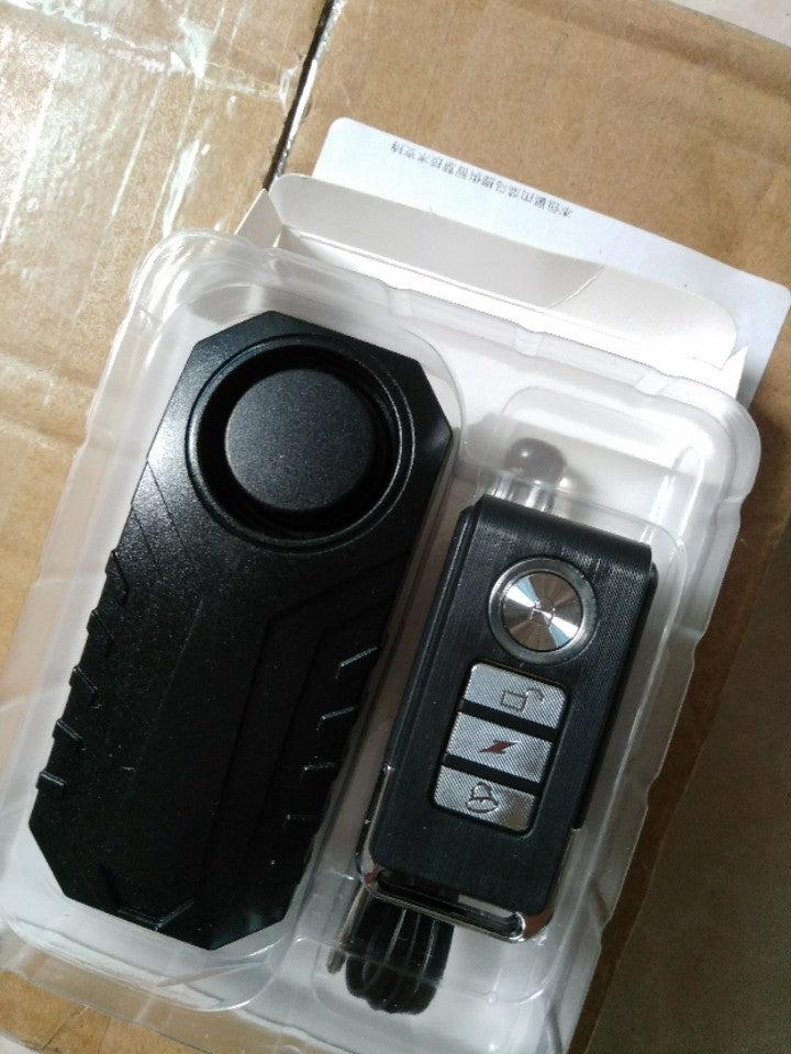 Car key fob and remote control in clear packaging on a cardboard surface