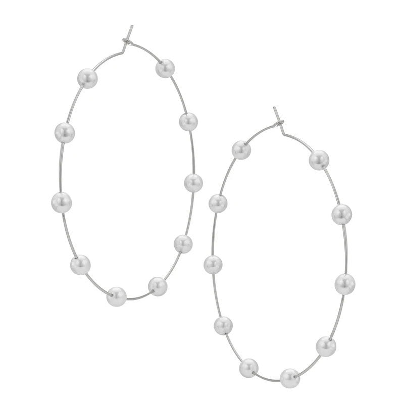 Pair of pearl hoop earrings on a white background