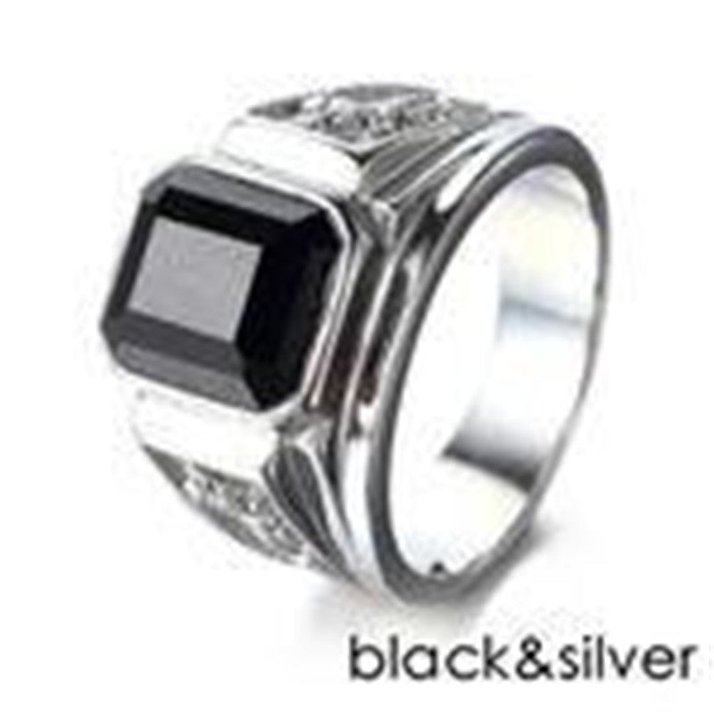 Silver ring with a black square stone on a white background