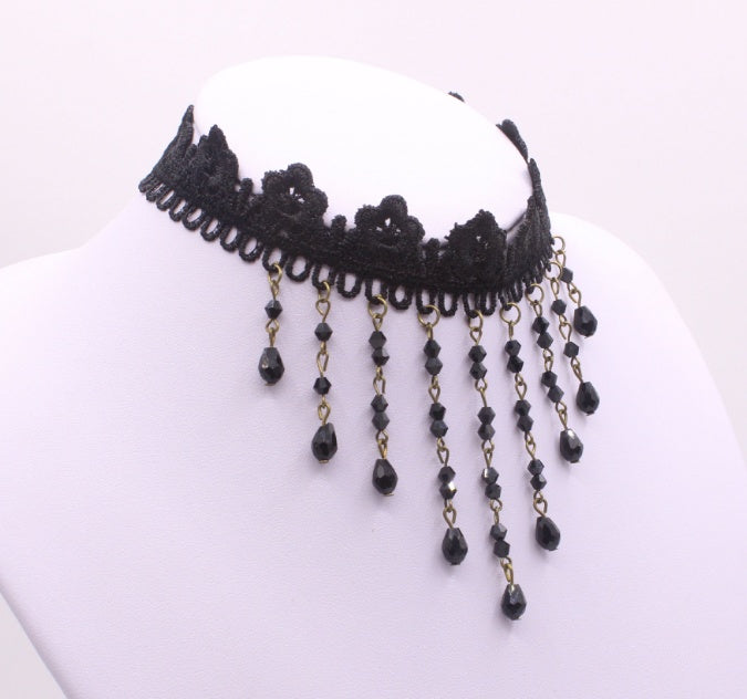 Black lace choker with dangling beads on a white background