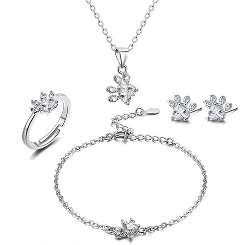 Silver jewelry set with ring, necklace, bracelet, and earrings on a white background