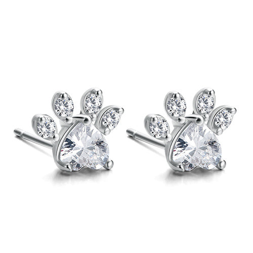 Pair of silver paw print earrings with clear gemstones on a white background