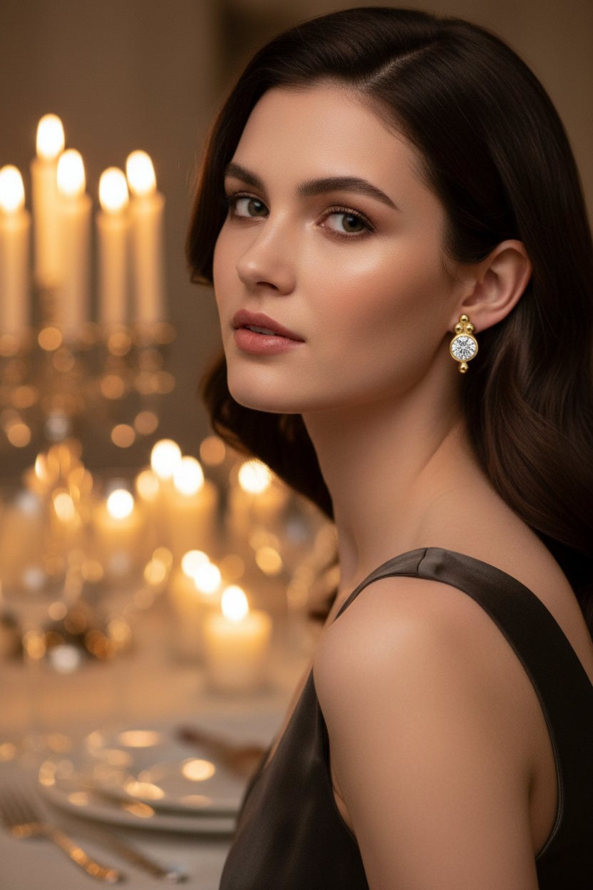 Gold earrings with round gemstones on a womans ears