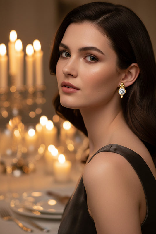 Gold earrings with round gemstones on a womans ears