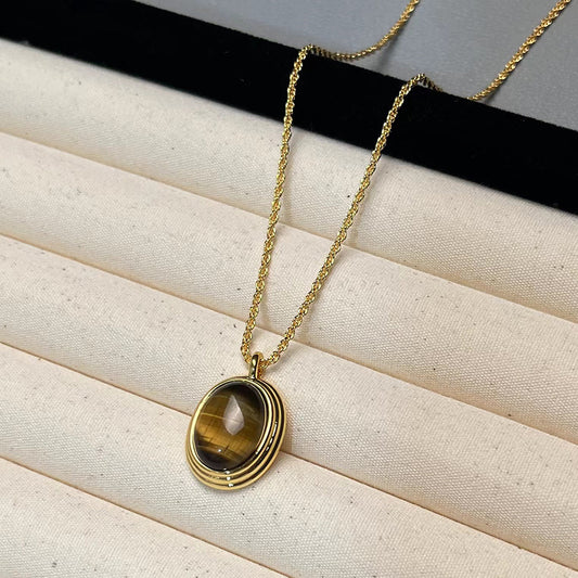 Gold necklace with a pendant on a textured surface