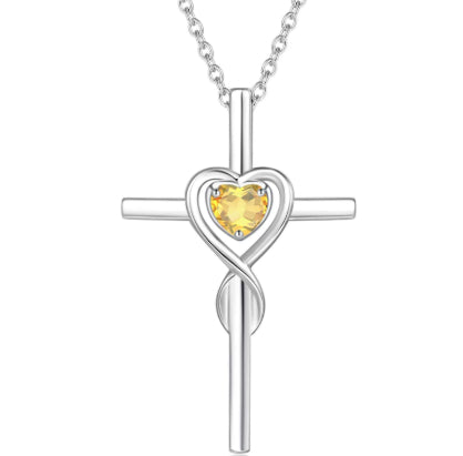 Birthstone  Silver cross necklace with a heart-shaped yellow gemstone on a white background