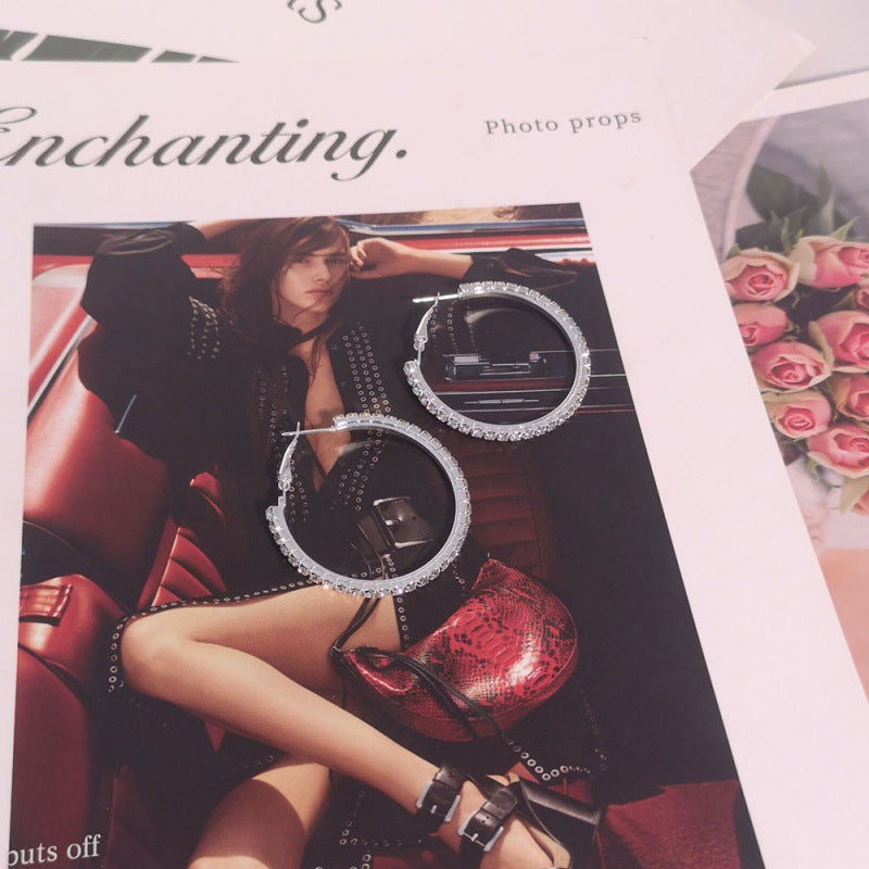 Person sitting in a car with large hoop earrings displayed, labeled 'Photo props'.