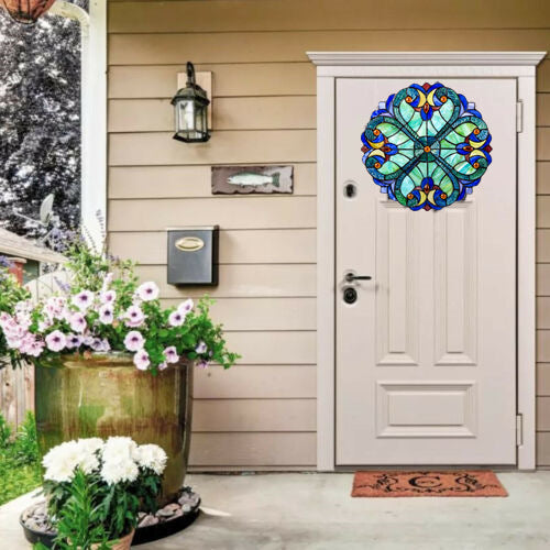 Decorative front door with stained glass design, potted flowers, and a doormat.