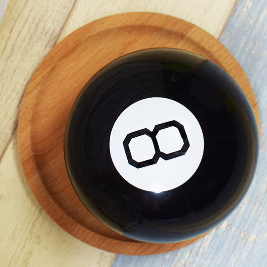 Black bowl with a white circle and black symbol on a wooden coaster
